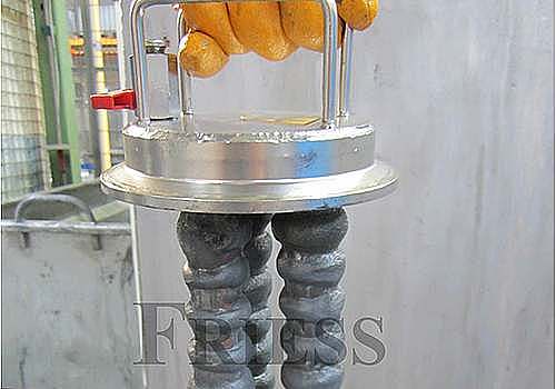 FRIESS FMF 磁性过滤器磁棒从过滤器壳体中提起，展示吸附的金属颗粒