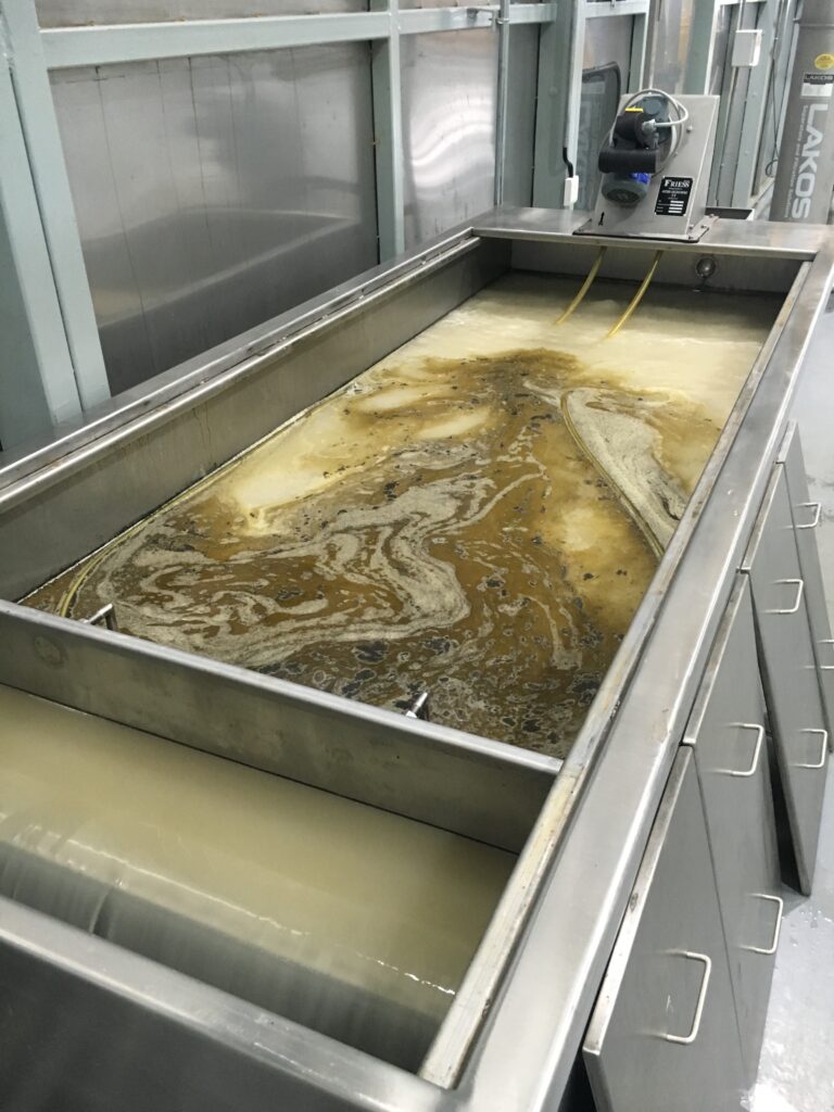 Floating oil in an SMT-FL separator tank with a FRIESS tube skimmer at the far end